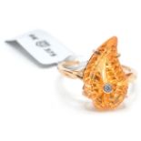 A hallmarked 9ct gold ring having a large centra orange stone in a shape of a leaf. Hallmarked
