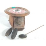 An antique style postman's clock having a oak frame with a pink face, Roman numerals to the