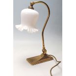 A 1920’s style Swan neck brass desk lamp having a milk glass scalloped edge glass shade with brass