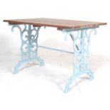 A RETRO VINTAGE 20TH CENTURY CAST IRON TABLE WITH SCROLED DECORATED BASE.