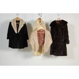 A group of four vintage fur coats to include a long brown mink coat, long white mink fur coat, black