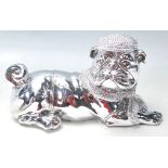 A LARGE SILVERED FIGURE OF A DOG WEARING A HAT AND SCARF.