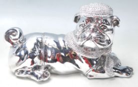 A LARGE SILVERED FIGURE OF A DOG WEARING A HAT AND SCARF.