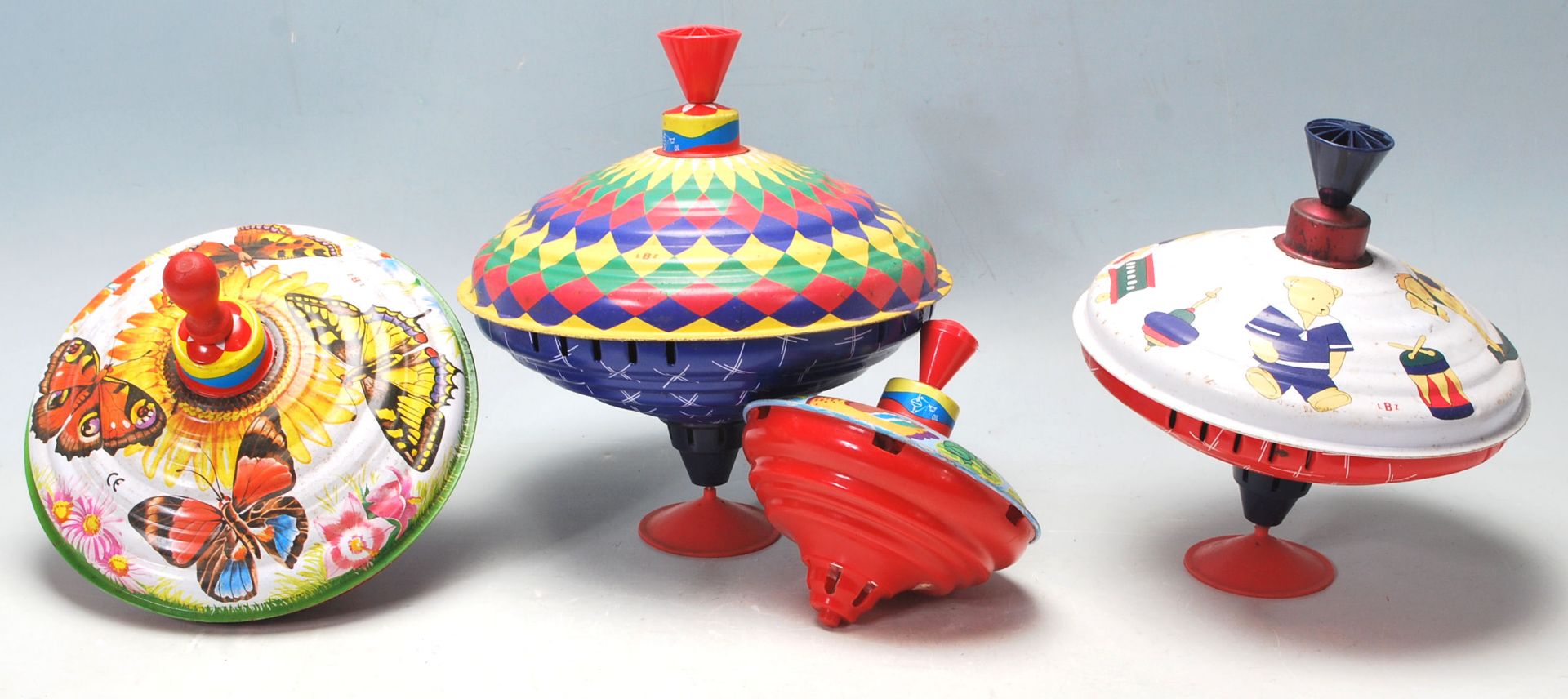 A COLLECTION OF FOUR TIN SPINNING TOYS IN A FORM OF UFO