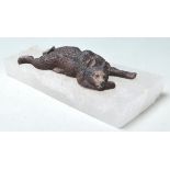 A PAPER WEIGHT COMPRISED OF A CAST IRON BEAR LAYING UPON A QUARTZ BASE