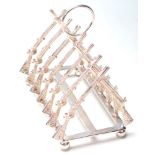 A SILVER PLATED TOAST RACK FORMED FROM CROSSED RIFLES.