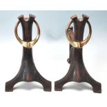 A PAIR OF VICTORIAN ART NOUVEAU IRON AND BRASS FIRE SIDE DOGS