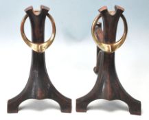 A PAIR OF VICTORIAN ART NOUVEAU IRON AND BRASS FIRE SIDE DOGS