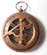 A BRASS DRY COMPASS WITH A SUNDIAL ATOP THE CASE.