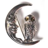 A STAMPED STERLING SILVER BROOCH DEPICTING AN OWL SAT UPON A CRESCENT MOON