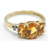 9CT GOLD RING SET WITH THREE OVAL CUT ORANGE STONES