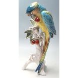 KARL ENS - CERAMIC PORCELAIN FIGURINES OF A PARROT EATING CHERRIES