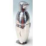 A STAINLESS STEEL COCKTAIL SHAKER IN THE FORM OF A PENGUIN WEARING A BOW TIE.