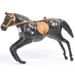 A VINTAGE LEATHER MODEL OF A HORSE WITH SADDLE