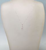 A STAMPED 18K WHITE GOLD PENDANT NECKLACE WITH A T