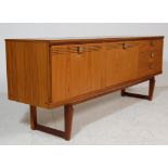 1970’S TEAK VENEER SIDEBOARD RAISED ON SHAPED SUPPORTS