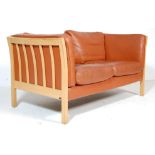 A MID CENTURY RETRO DANISH SCANDINAVIAN SOFA HAVING BEECH WOOD CONSTRUCTION AND TAN LEATHER SEATS.