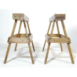 A PAIR OF MID CENTR WOODEN PLANT STANDS OF A TRESTLES DESIGN
