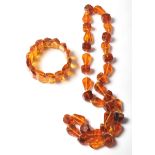 A FAUX AMBER RESIN NECKLACE AND BRACELET.