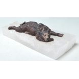 A PAPER WEIGHT COMPRISED OF A CAST IRON BEAR LAYIN