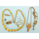 A gold-plated chatelaine, a string of yellow glass beads and other items.