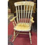 A stained wood slat-back farmhouse-style rocking chair.
