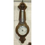A late-Victorian carved oak aneroid barometer/thermometer by Solanson & Co, Bristol, 92cm high.