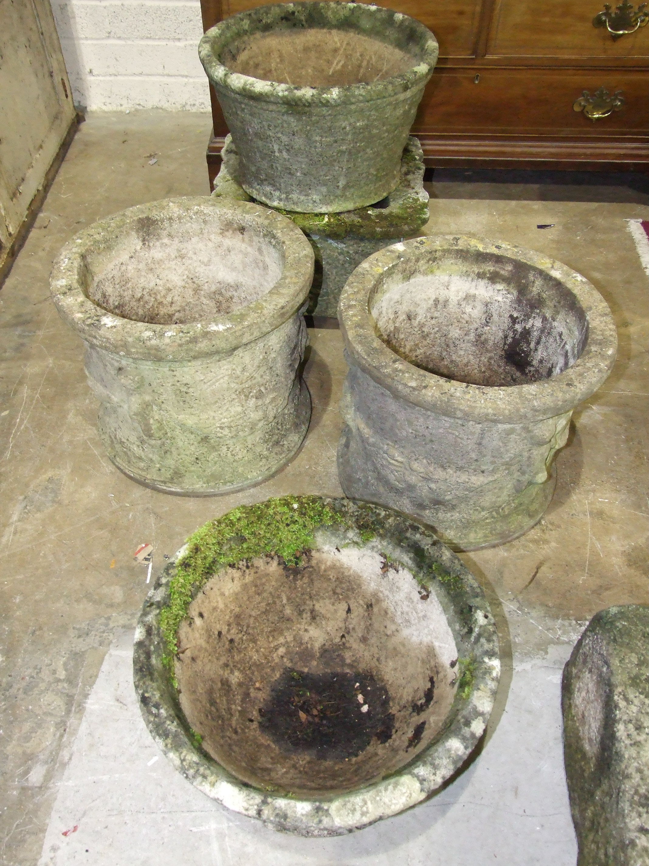 A pair of reconstituted stone circular garden planters moulded with cherubs, 43cm diameter, 39cm