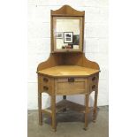 An early-20th century light oak corner wash stand in the Arts & Crafts taste, the adjustable