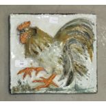 An art pottery tile with raised cockerel decoration, 25 x 27cm and an art pottery reclining nude