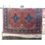 An Oriental rug with red ground, 197 x 137cm.
