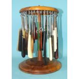 A turned wood button hook stand of carousel form, with 46 various button hooks.