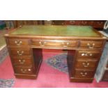 An early-20th century walnut knee-hole pedestal desk fitted with nine drawers, 120cm.