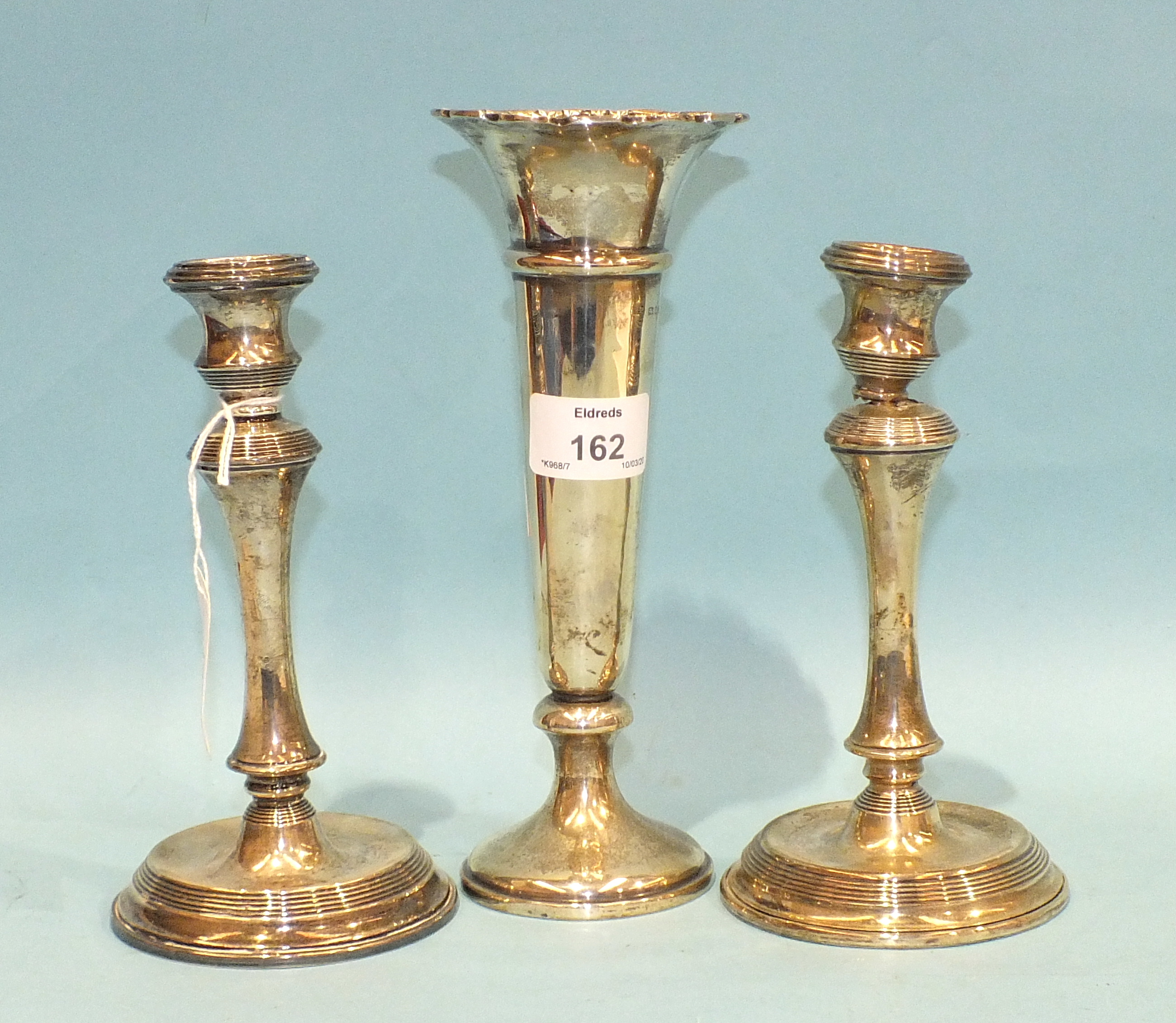 A pair of short loaded silver candlesticks on circular bases, Birmingham 1909 and a plain loaded