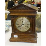 An oak-cased striking mantel clock of architectural design, the dial marked Masons, Middlesbrough,