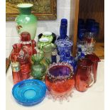 A collection of various coloured glassware, including cranberry and Bristol Blue vases, drinking