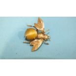 A gold bee brooch, the abdomen claw-set a tiger's eye round cabochon, unmarked, (tested as 14ct gold