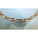 An 18ct white and rose gold necklet composed of alternate white gold rectangular links and rose gold
