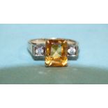 A 9ct yellow gold ring set a step-cut citrine, between two synthetic white sapphires, size R, 4.1g.