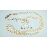 A string of graduated cultured pearls with silver clasp and two pairs of cultured pearl earrings