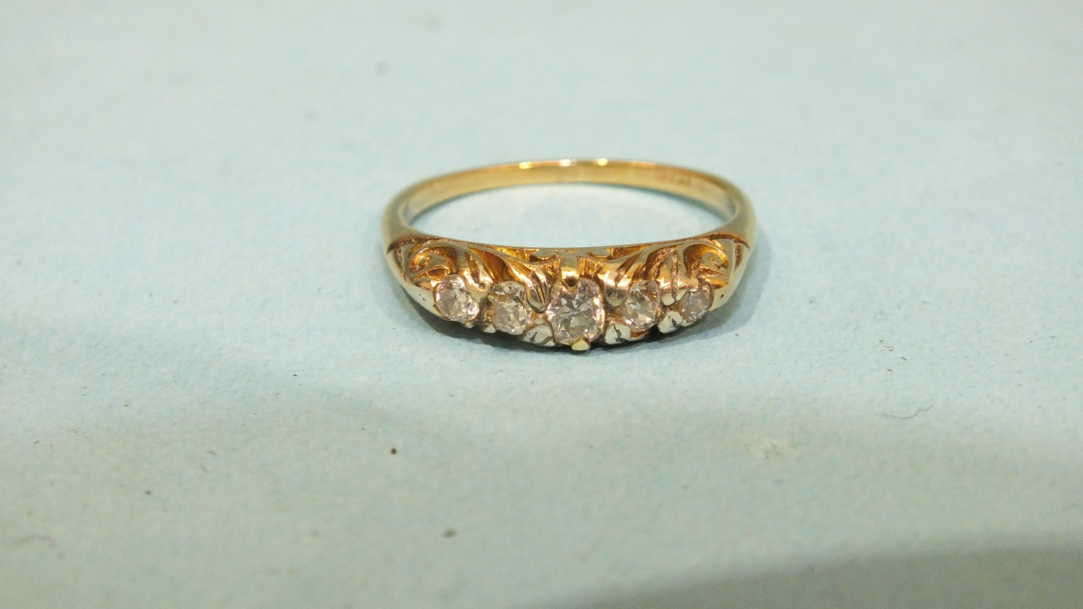 A five-stone diamond ring, the old brilliant-cut diamonds in 18ct gold mount, size Q, 3.6g.