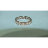 A diamond eternity ring claw-set seventeen brilliant-cut diamonds, in unmarked white metal mount,