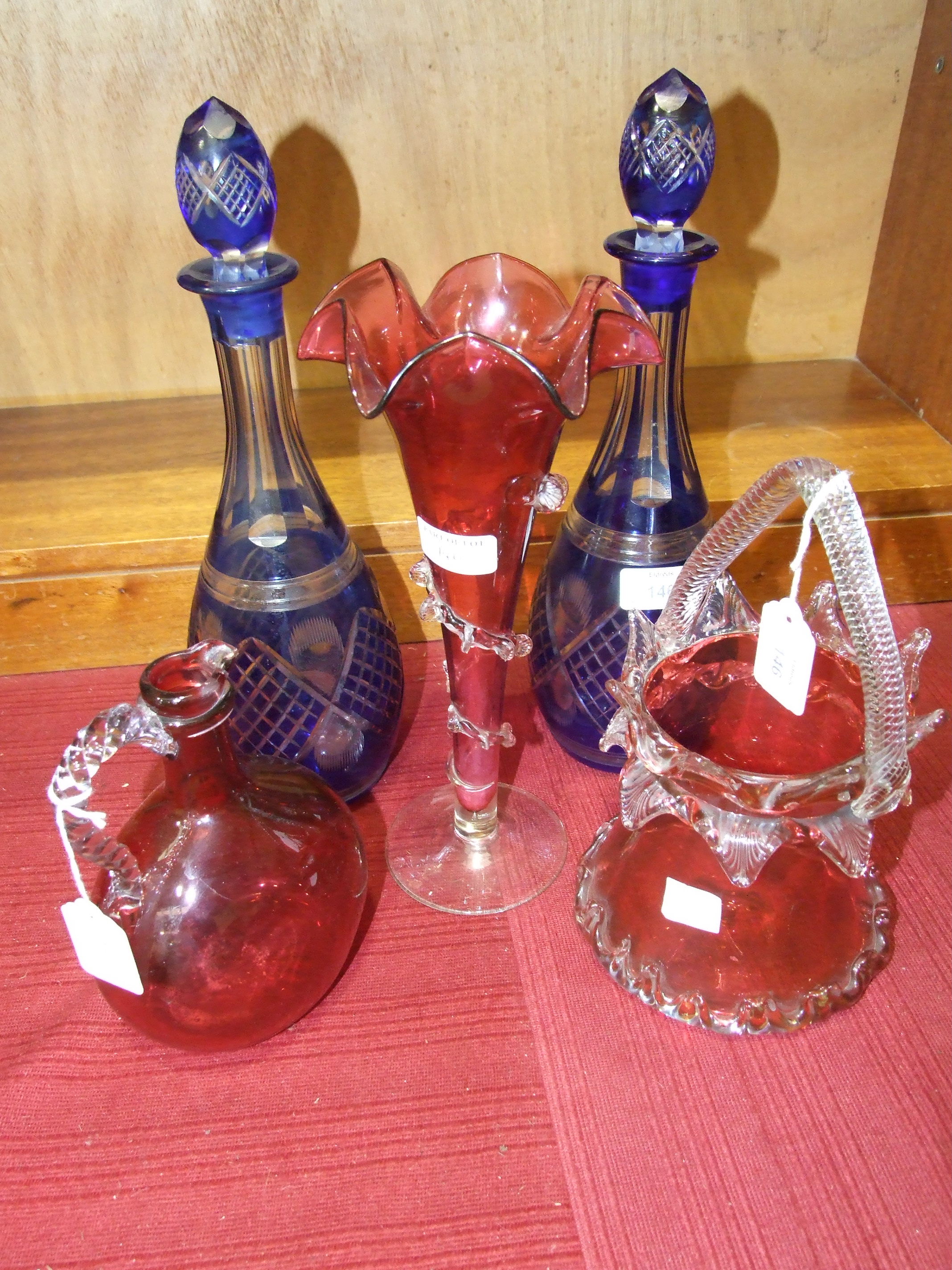 A pair of 20th century blue overlay glass decanters with stoppers, 27cm high, a cranberry glass