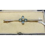 An Edwardian bar brooch centrally-set four oval aquamarines around a cultured pearl bead, in 15ct