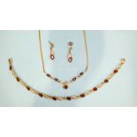 A 9ct gold necklet set garnets and diamond points, a pair of matching drop earrings and a similar