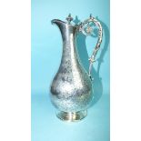 A late-Victorian silver wine ewer with leaf-decorated scroll handle, hinged finialed lid, the body