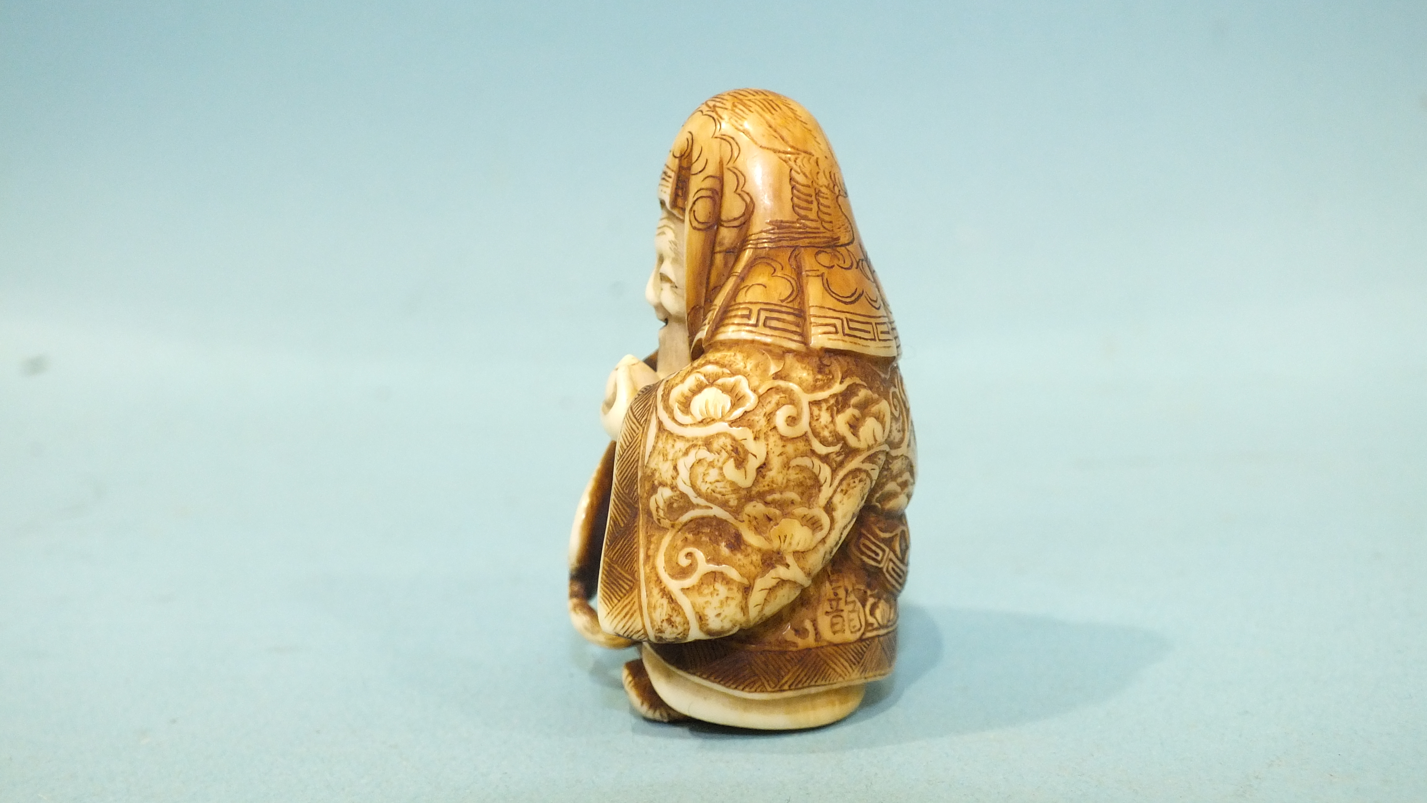 A mid to late-19th century ivory netsuke of Jurojin holding a fan and a tama, his robes finely- - Image 2 of 5