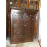 An antique oak cupboard, the carved cornice above a pair of panelled doors, 136cm wide, 165cm high.