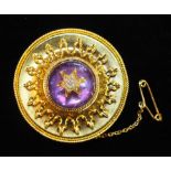 A Victorian yellow gold circular brooch c1860, set amethyst cabochon overlaid with old brilliant and
