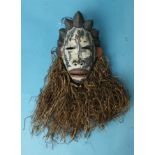 An unusual Gabon Punu pottery face mask, the face with characteristic hair braiding and raffia